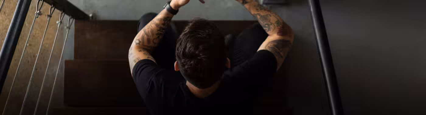 Igor sentado na escada mexendo no celular